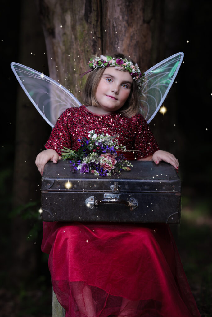 Kinderportrait von einem Mädchen mit Koffer im Zauberwald in Fichtenau nahe Crailsheim.
